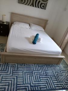 Una cama blanca con una toalla azul. en Serendipity Apartment, en Flic en Flac