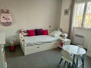 - une chambre avec un lit doté d'oreillers roses et d'une table dans l'établissement Maison 3 chambres avec piscine proche Avignon, à Sorgues