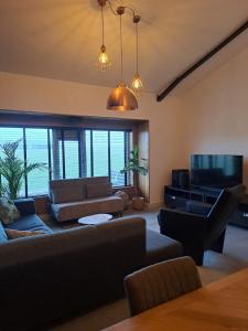 uma sala de estar com sofás e uma televisão de ecrã plano em Villa the Tulip JACK em Julianadorp