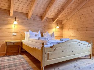 een slaapkamer met een bed in een blokhut bij 1A Chalet Koralpenzauber - Wandern, Sauna, Grillen mit Traumblick in Wolfsberg