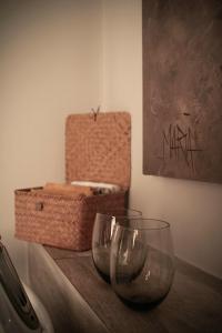 two wine glasses sitting on a table with a basket at C-Vu-Cottage cosy and warm private apartment in Mossel Bay