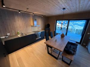 uma cozinha com uma mesa de madeira e uma grande janela em Moderne hytte på Fjellsætra, Ski in/Out, Familievennlig em Sykkylven