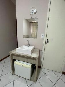 a bathroom with a sink and a mirror at Hotel Villa Souza Ltda in Santa Cruz do Sul
