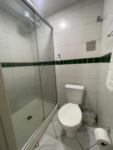 y baño blanco con aseo y ducha. en Hotel Villa Souza Ltda en Santa Cruz do Sul