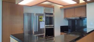a kitchen with a stainless steel refrigerator and a stove at Moana Luxury Residence in Honolulu