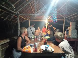 um grupo de pessoas sentadas à mesa em Ransiwor Homestay em Kri