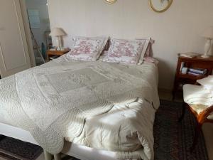 a bedroom with a bed with pink and white sheets and pillows at Capucine in Noyen-sur-Sarthe