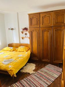 a bedroom with a bed and a large wooden cabinet at Apartament Cornelia in Buzău