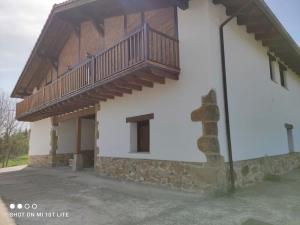 un edificio con un balcón en el lateral. en Apartamento rural con entrada independiente, en Múgica