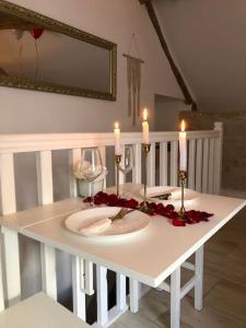 a white table with candles and red roses on it at Maisonnette spa privée - terrasse commune in Talant