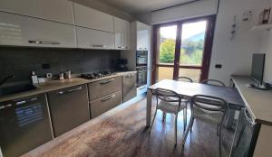 a kitchen with a table and two chairs in it at Casa Vignolet : la finestra su Pont-Saint-Martin in Pont-Saint-Martin