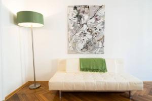 uma sala de estar com um sofá branco e um candeeiro em Vienna Residence, Gumpendorfer Straße - Mariahilf #527 em Viena