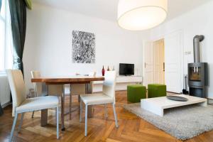 ein Wohnzimmer mit einem Tisch und grünen Stühlen in der Unterkunft Vienna Residence, Gumpendorfer Straße - Mariahilf #527 in Wien
