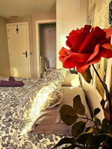 ein Schlafzimmer mit einem Bett mit roten Blumen darauf in der Unterkunft AdriVA Fuente Dorada-Plaza Mayor, Wifi Atico in Valladolid
