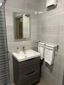a bathroom with a sink and a mirror and towels at Chapel Place, Town Centre in Killarney