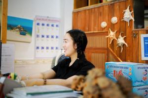 a woman sitting at a desk in a room at Sông Suối Homestay in Quy Nhon