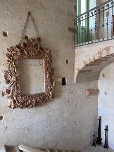 uno specchio appeso a un muro accanto a una scala di Palazzo Siena - Home & More a Minervino di Lecce