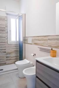 Baño blanco con aseo y lavamanos en casa Taormina, en Letojanni