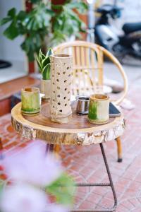 une table en bois avec quatre tasses au-dessus dans l'établissement Sông Suối Homestay, à Quy Nhơn