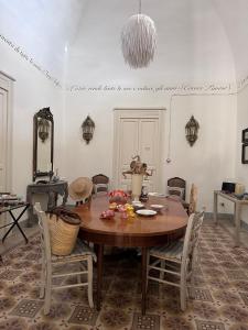 ein Esszimmer mit einem Holztisch und Stühlen in der Unterkunft Palazzo Siena - Home & More in Minervino di Lecce