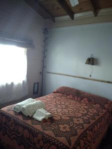 1 dormitorio con 1 cama con manta y ventana en Cabañas Nontue en Tigre