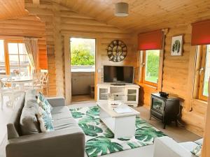 a living room with a couch and a tv in a cabin at Little Eden Country Park, Bridlington with Private Hot Tubs in Bridlington