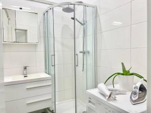 a white bathroom with a shower and a sink at 55m2 Stylish Apartment with Netflix - 15 min to Center in Vienna