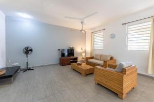 a living room with a couch and a tv at Cocobana Resort two-bedroom apartment ground floor in Willemstad