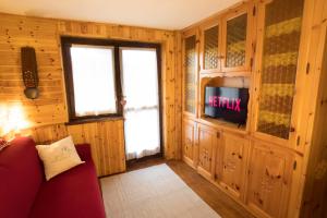 a living room with a red couch and a window at [Cervinia Center] 2 min to SKI + FREE GARAGE in Breuil-Cervinia