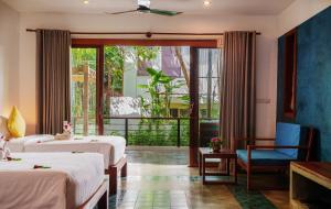 a hotel room with two beds and a balcony at SAKABAN Residence in Siem Reap