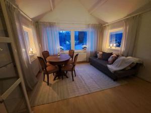 ein Wohnzimmer mit einem Tisch und einem Sofa in der Unterkunft Litet strandnära hus på Adelsö in Adelsö