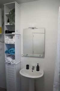 a bathroom with a sink and a mirror and towels at Fifty´s House in Ribeira Brava