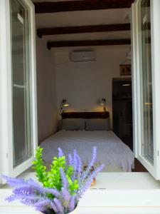 a bedroom with a bed with two windows and purple flowers at Kavousi Cottages - H Petra in Kavoúsion
