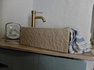 a sink with a towel and a faucet on a counter at Kavousi Cottages - H Petra in Kavoúsion +11 photos