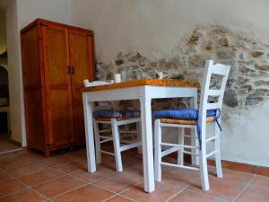 a kitchen with a table and two stools at Kavousi Cottages - H Petra in Kavoúsion