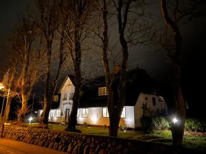 ein weißes Haus in der Nacht mit Bäumen in der Unterkunft Hotel Seiler Hof Keitum garni in Keitum