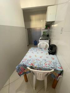 una pequeña cocina con mesa y sillas. en Apartamento a 1 km da Orla de Atalaia en Aracajú