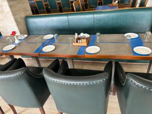 a table with plates and chairs in a restaurant at Hotel Vinnie in Jaipur