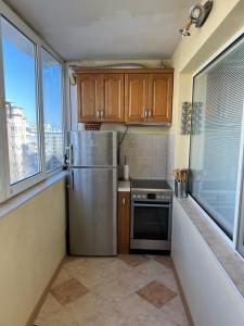una cucina con frigorifero in acciaio inossidabile e finestre di Business Park Sofia Apartment a Sofia