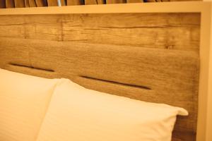 cabecero de cama con almohadas blancas en Hols Apartments, en Kaduna
