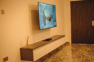 a living room with a television on the wall at Hols Apartments in Kaduna