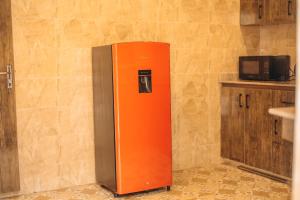 an orange and gray refrigerator in a kitchen at Hols Apartments in Kaduna