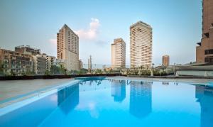 فندق بيراميزا سويتس القاهرة في القاهرة: مسبح في مدينة ذات مباني طويلة