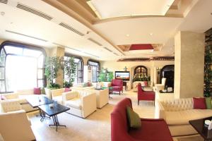 a lobby with couches and chairs and a television at Pyramisa Suites Hotel Cairo in Cairo