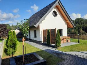 una pequeña casa blanca con un banco en el patio en Beim Schlafwandler, en Virneburg