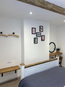 a bedroom with a white wall with pictures on the wall at Nine Cooper Lane, Holmfirth in Holmfirth