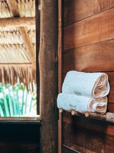 una pila de toallas en una pared de madera en Villa Sabiá - Eco Bungalows, en Prea