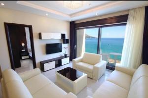 a living room with two white couches and a view of the ocean at See View Apartment Budva Becici in Budva