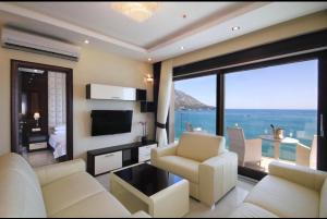 a living room with white furniture and a large window at See View Apartment Budva Becici in Budva