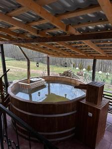 a large wooden hot tub under a wooden roof at Pensiunea Daiadela in Duşeşti